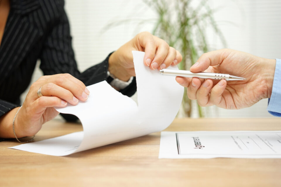 Woman tears agreement documents  in front of agent