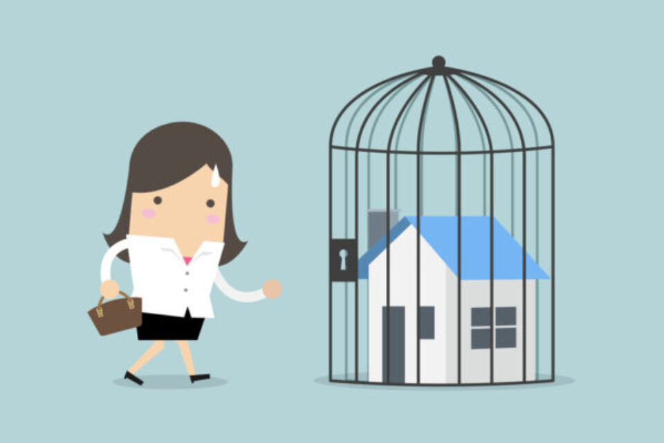 Businesswoman with locked house inside the cage, home foreclosure.