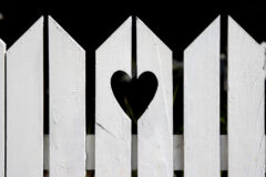 Heart shape cut out of white suburban residential fence