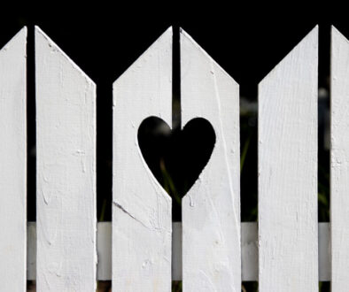 Heart shape cut out of white suburban residential fence