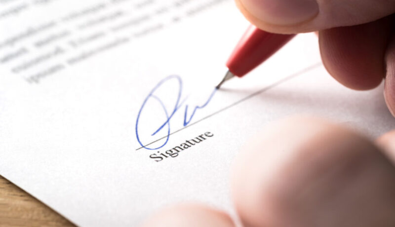 Signing contract, lease or settlement for acquisition, apartment lease, insurance, bank loan, mortgage or business buyout. Man writing name and autograph with pen. The signature is made up.