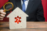 A man examines a house with a missing puzzle inside. Property valuation. Finding problems and structural hidden defects. Checking for compliance with the parameters criteria. Solving housing problems A man examines a house with a missing puzzle inside. Property valuation. Finding problems and structural hidden defects. Checking for compliance with the parameters criteria. Solving housing problems